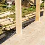 Outdoor construction site with vertical wooden beams for a frame house