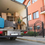 Van full of moving boxes and furniture near house