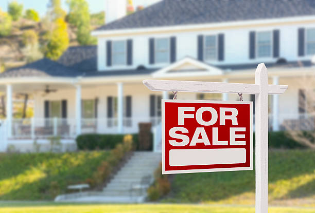 Home For Sale Real Estate Sign in Front of Beautiful New House.
