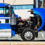 Broken down semi truck in a parking lot.