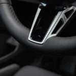 Detailed view of a premium leather steering wheel with silver trim.