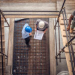 Construction workers and architects at a construction site viewed from above.